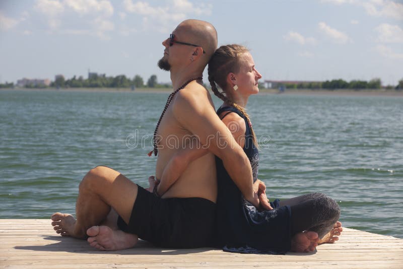 Mannen och gravida kvinnan g?r yoga p? stranden royaltyfria bilder Mannen och gravida kvinnan g?r yoga p? stranden royaltyfria bilder