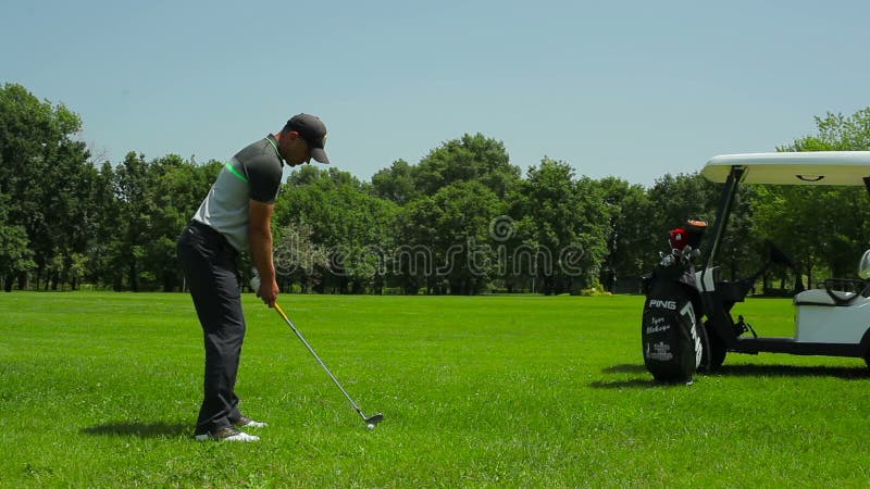 Mannen slår bollen i golf