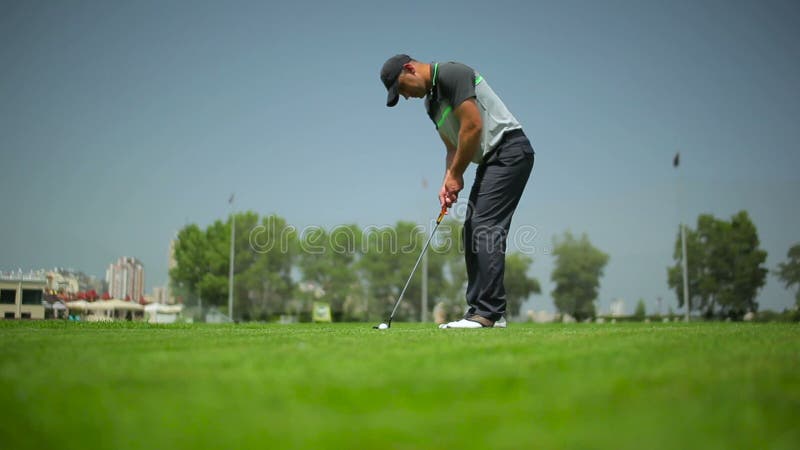 Mannen slår en klubba på bollen i golf