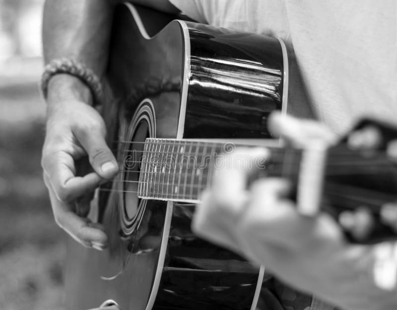 Mannen spelar gitarren i svartvita signaler royaltyfri bild
