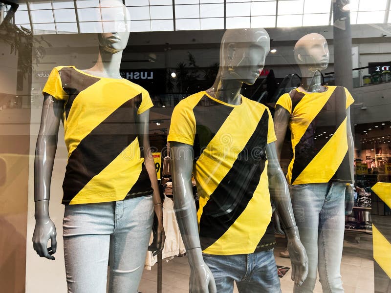 : Mannequins wyświetlający żółte i czarne koszulki w oknie centrum handlowym fotografia stock