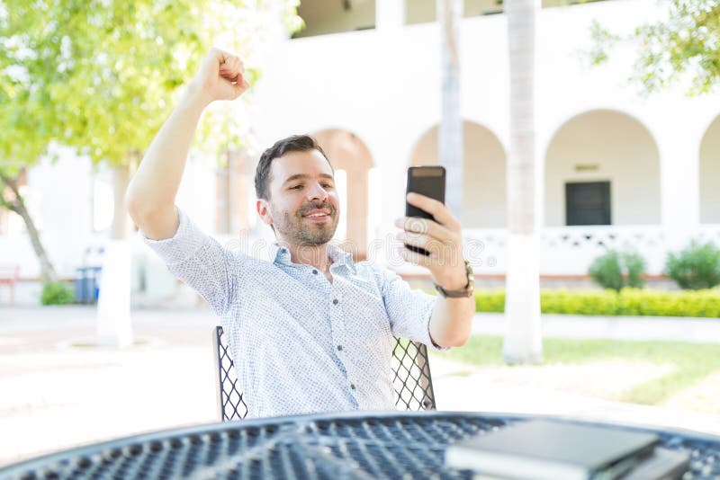 Mannetje met Opgeheven Wapen het Krijgen van Goed Nieuws op Mobiele Telefoon stock foto Mannetje met Opgeheven Wapen het Krijgen van Goed Nieuws op Mobiele Telefoon stock foto