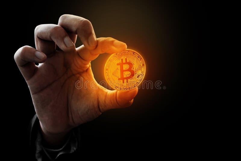 Männliche Hand hält einen goldenen Bitcoin lizenzfreies stockfoto