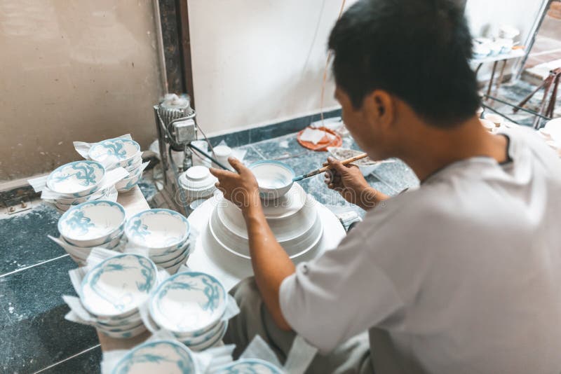 Mannmalerei auf Keramikschüsseln in Vietnam stockbild Mannmalerei auf Keramikschüsseln in Vietnam stockbild