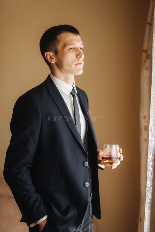 Mannstand von Seite zu Fenster und drind ein wiskey lizenzfreie stockbilder Mannstand von Seite zu Fenster und drind ein wiskey lizenzfreie stockbilder