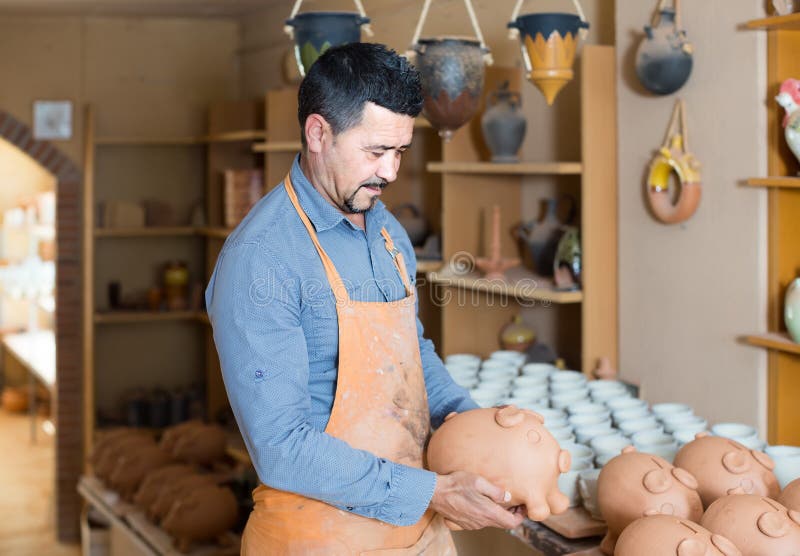 Manntöpfer, der keramische Schiffe im Atelier hält stockbild Manntöpfer, der keramische Schiffe im Atelier hält stockbild