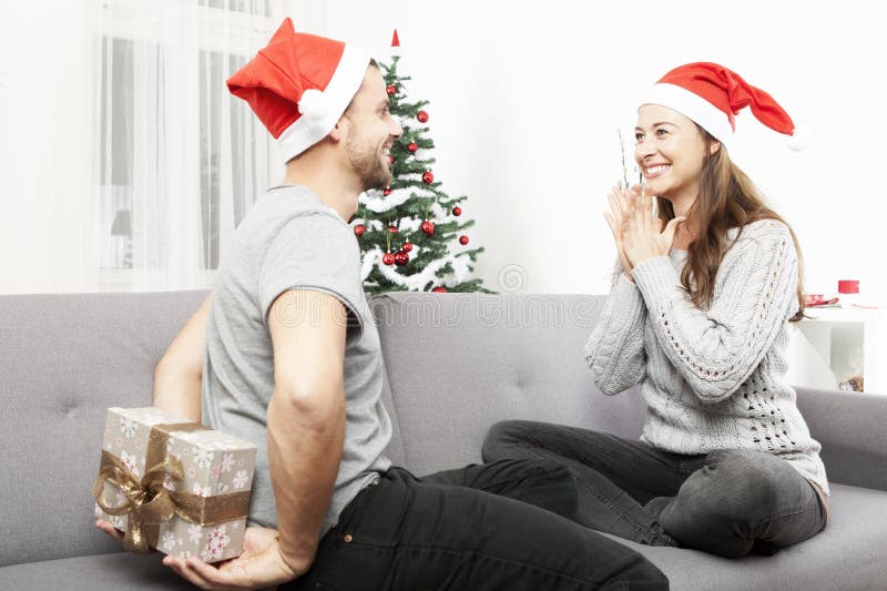 Mannüberraschungsfreundin mit Weihnachtsgeschenk stockfoto Mannüberraschungsfreundin mit Weihnachtsgeschenk stockfoto