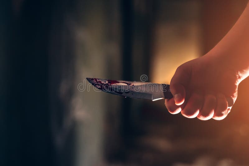 Mano asesina sosteniendo un cuchillo en sangre en casa de miedo oscuro imágenes de archivo libres de regalías Mano asesina sosteniendo un cuchillo en sangre en casa de miedo oscuro imágenes de archivo libres de regalías