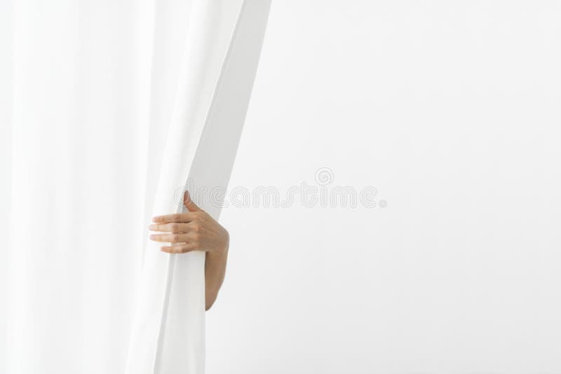 Mano che apre una tenda bianca fotografie stock libere da diritti