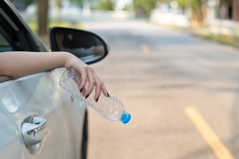 Mano che getta bottiglia di plastica sulla strada immagini stock Mano che getta bottiglia di plastica sulla strada immagini stock