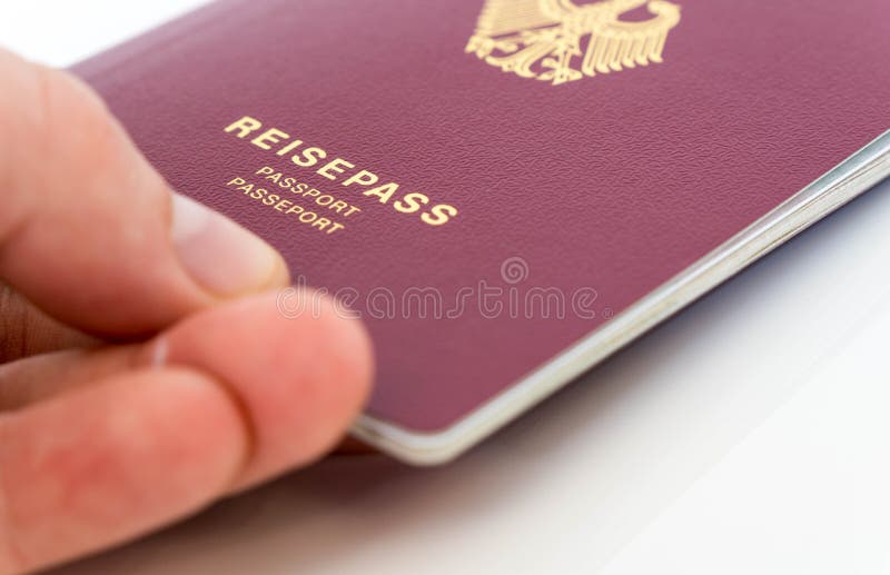 Mano che tiene passaporto tedesco fotografia stock Mano che tiene passaporto tedesco fotografia stock