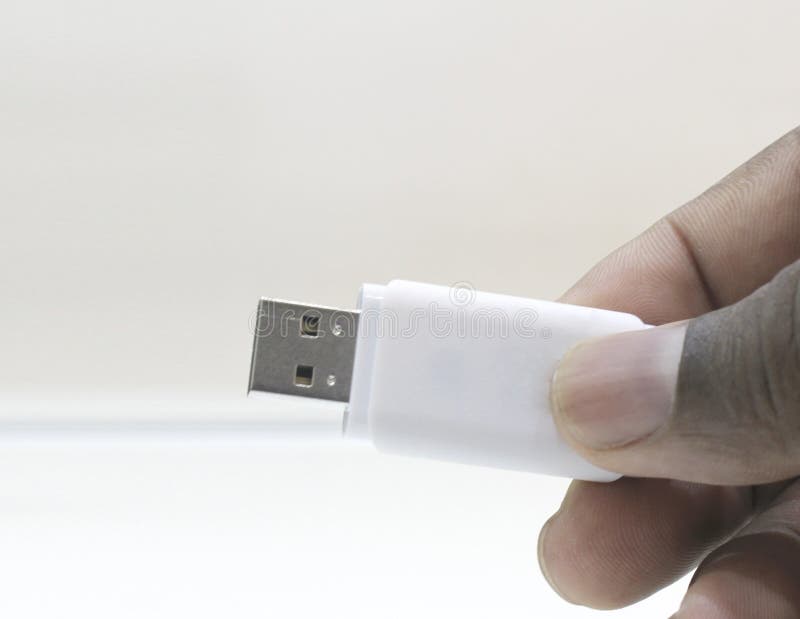Mano che tiene una chiavetta USB su un fondo bianco fotografia stock Mano che tiene una chiavetta USB su un fondo bianco fotografia stock