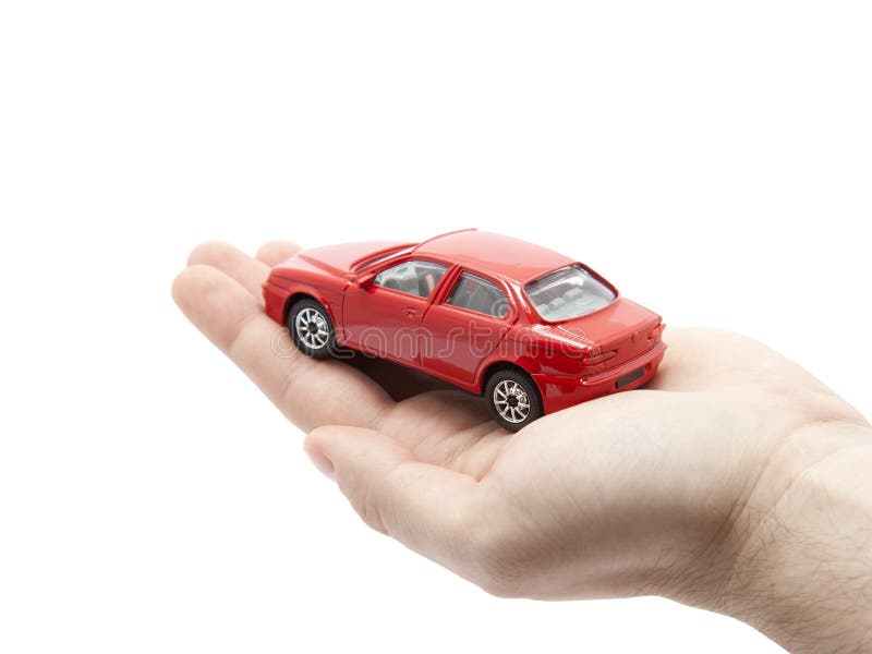 Mano che tiene una piccola automobile rossa fotografia stock Mano che tiene una piccola automobile rossa fotografia stock