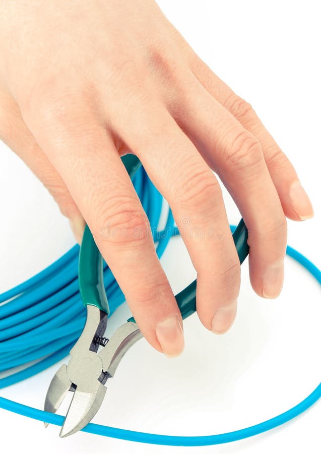 Mano con las pinzas y cable azul en el fondo blanco, concepto de la ingeniería eléctrica foto de archivo Mano con las pinzas y cable azul en el fondo blanco, concepto de la ingeniería eléctrica foto de archivo
