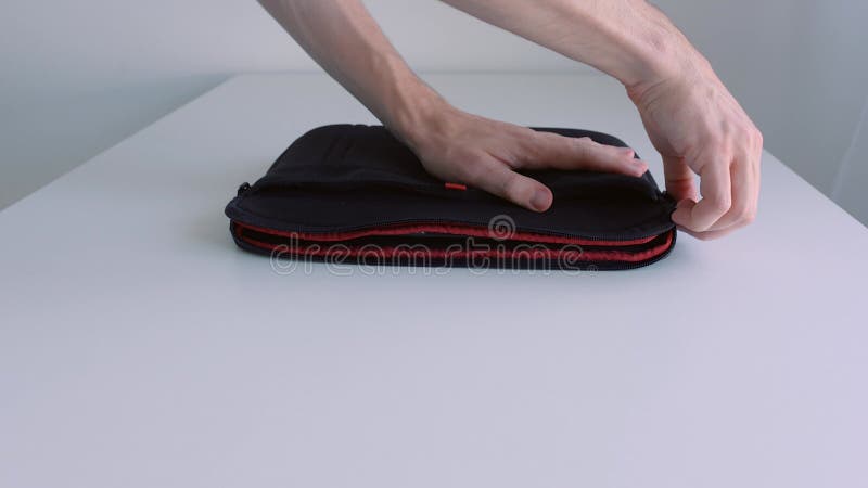 Mano de hombre que pone un portátil en un estuche que lo deja caer y se quita de la mesa. acción. cierre de la posición de la mano almacen de metraje de vídeo