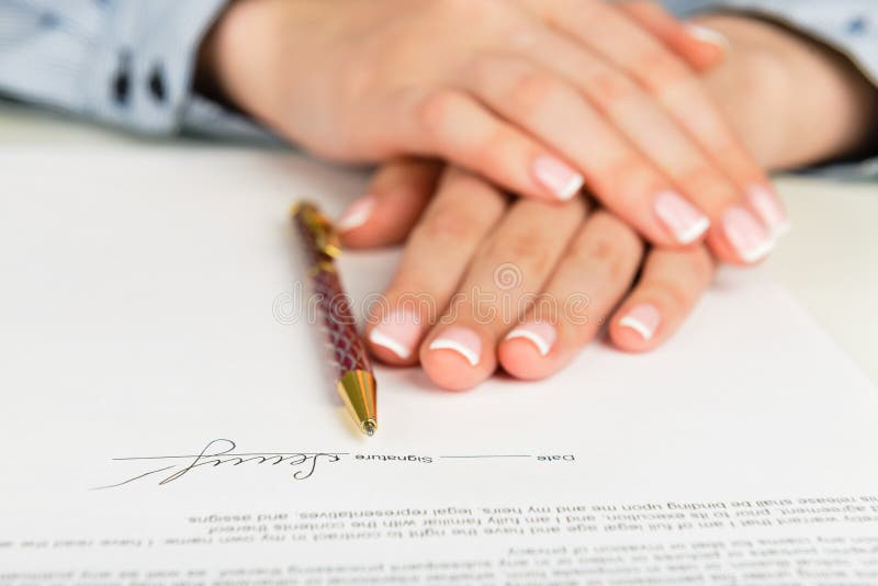 Mano de la mujer que firma un contrato imagen de archivo libre de regalías Mano de la mujer que firma un contrato imagen de archivo libre de regalías