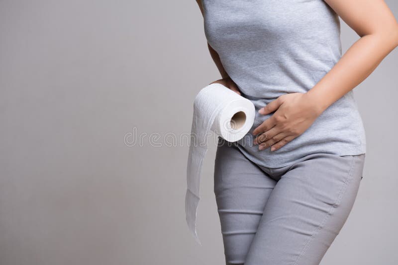 Woman hand holding her crotch lower abdomen and tissue or toilet paper roll. Disorder, Diarrhea, incontinence. Healthcare concept. Woman hand holding her crotch lower abdomen and tissue or toilet paper roll. Disorder, Diarrhea, incontinence. Healthcare concept.