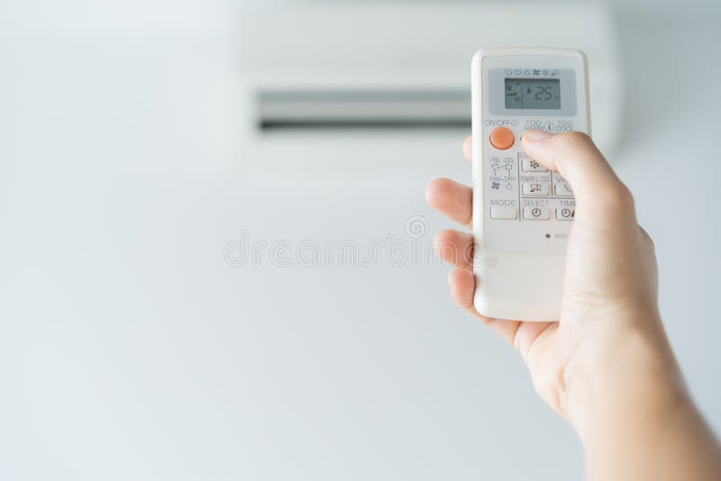 Mano de la mujer usando el aire acondicionado abierto teledirigido 25 grados El aire abierto 25 grados, es temperatura, energ?a d imagen de archivo libre de regalías Mano de la mujer usando el aire acondicionado abierto teledirigido 25 grados El aire abierto 25 grados, es temperatura, energ?a d imagen de archivo libre de regalías