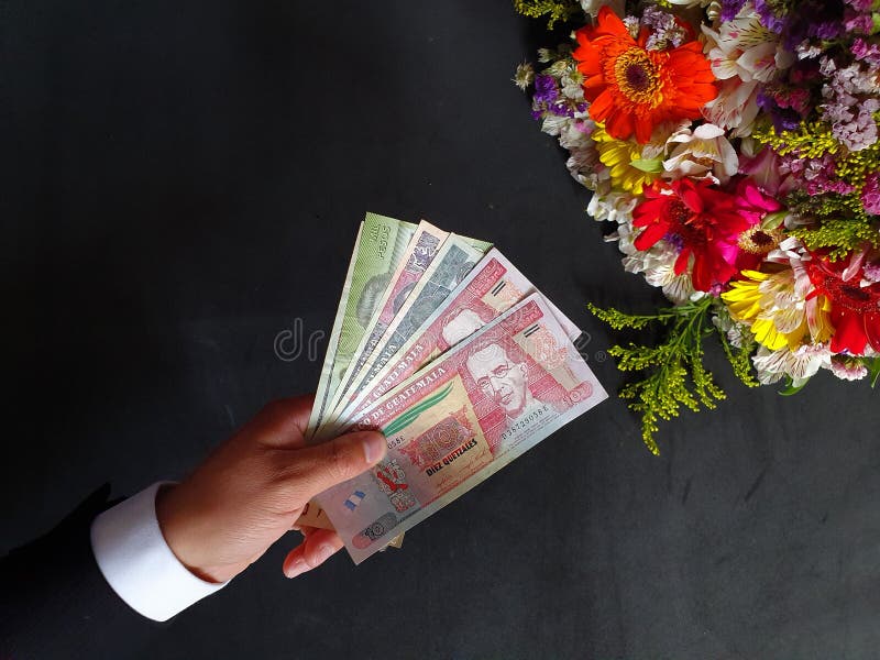 Mano De Un Hombre Que Paga Con Dinero Guatemalteco Por Un Ramo De Flores  Imagen de archivo - Imagen de mano, dinero: 158495655