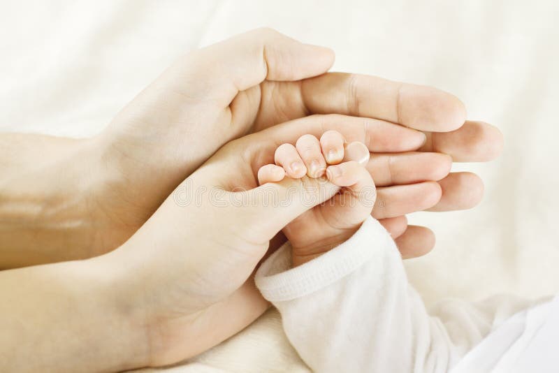 Mano del bebé dentro de las manos de los padres. Concepto de familia