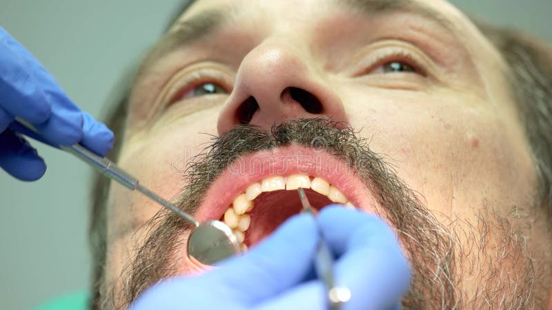 Mano del dentista con lo strumento