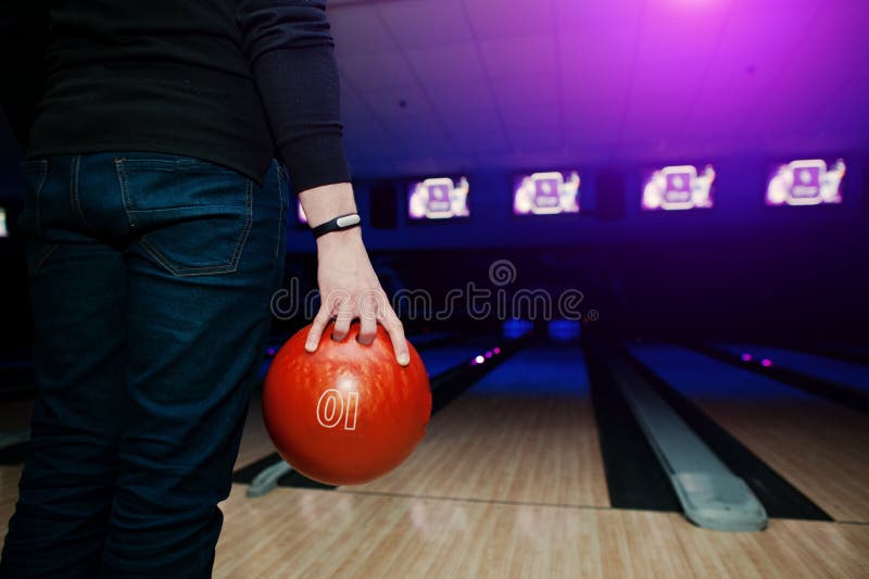 Mano del giocatore dell'uomo con la palla da bowling della tenuta del braccialetto fotografie stock Mano del giocatore dell'uomo con la palla da bowling della tenuta del braccialetto fotografie stock