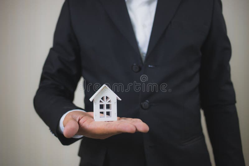 Mano del hombre de negocios que sostiene la casa blanca modelo La inversión y la casa de la propiedad hipotecan el concepto finan fotos de archivo libres de regalías Mano del hombre de negocios que sostiene la casa blanca modelo La inversión y la casa de la propiedad hipotecan el concepto finan fotos de archivo libres de regalías