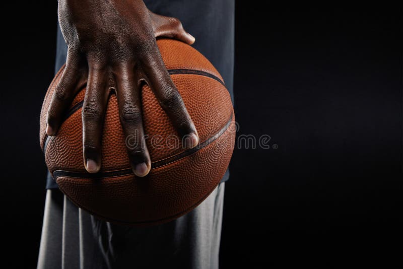 Mano del jugador de básquet que sostiene una bola imagenes de archivo Mano del jugador de básquet que sostiene una bola imagenes de archivo