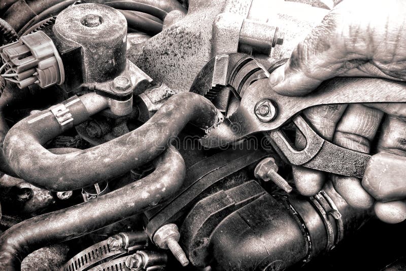 Mano del meccanico di riparazione automatica che ripara una parte di motore dell'automobile fotografia stock Mano del meccanico di riparazione automatica che ripara una parte di motore dell'automobile fotografia stock