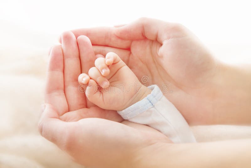 Mano del neonato in mani della madre. Concetto di asistance di aiuto