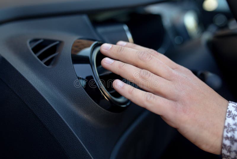 Mano dell'autista sulla griglia di ventilazione dell'aria con il regolatore di potere, dettaglio interno dell'automobile moderna fotografie stock libere da diritti Mano dell'autista sulla griglia di ventilazione dell'aria con il regolatore di potere, dettaglio interno dell'automobile moderna fotografie stock libere da diritti