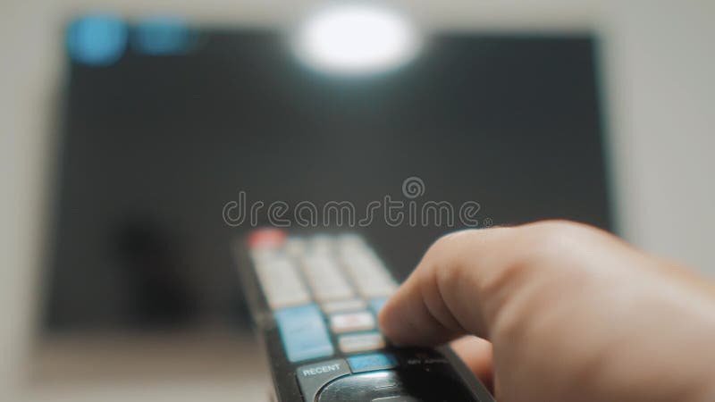 Mano dell'uomo che tiene il telecomando della TV e spegnere TV astuta Scav canaliare praticare il surfing La fine su equipaggia l