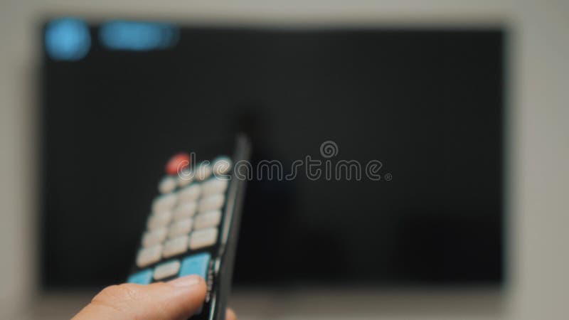 Mano dell'uomo che tiene il telecomando della TV e spegnere TV astuta Scav canaliare praticare il surfing La fine su equipaggia l