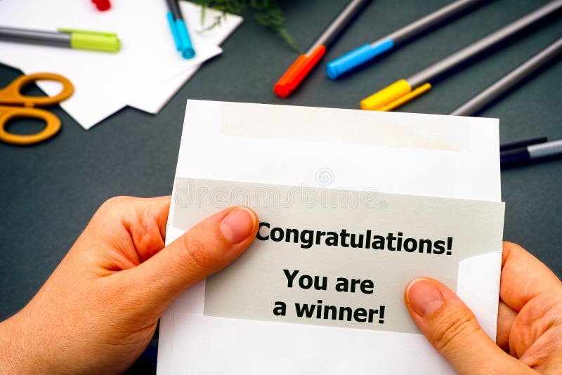 Mano della donna che elimina lettera con le congratulazioni di parole! Siete un vincitore! dalla busta immagine stock libera da diritti Mano della donna che elimina lettera con le congratulazioni di parole! Siete un vincitore! dalla busta immagine stock libera da diritti