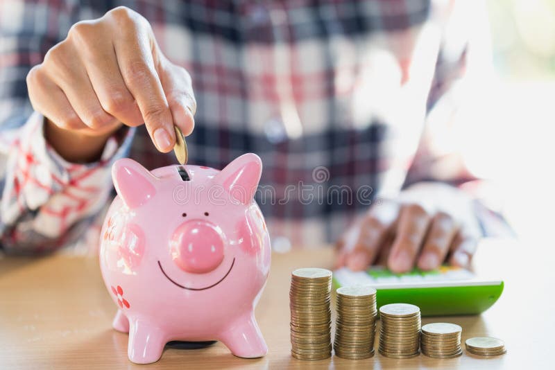 Mano della donna che mette moneta nel porcellino salvadanaio Ricchezza di risparmio dei soldi e immagine stock Mano della donna che mette moneta nel porcellino salvadanaio Ricchezza di risparmio dei soldi e immagine stock