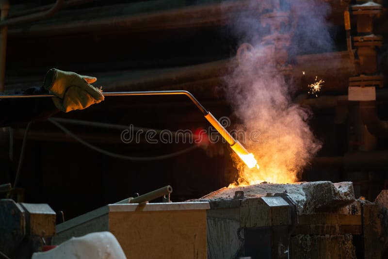 hand of foundry worker measuring temperature of molten steel in ladle with ceramic probe. hand of foundry worker measuring temperature of molten steel in ladle with ceramic probe