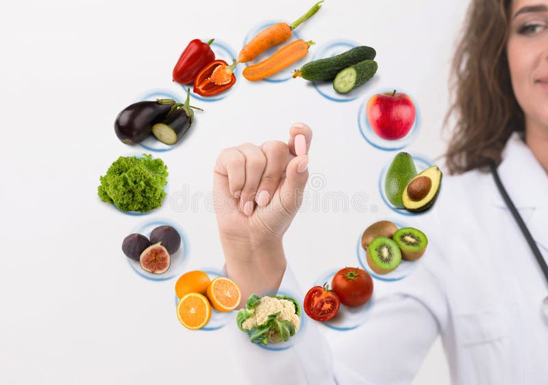 Mano di medico del dietista che mostra pillola sui frutti di simboli immagine stock Mano di medico del dietista che mostra pillola sui frutti di simboli immagine stock