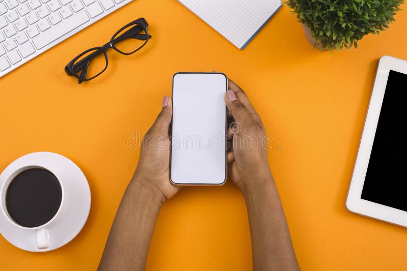 Mano facendo uso dello smartphone su fondo di legno bianco fotografia stock Mano facendo uso dello smartphone su fondo di legno bianco fotografia stock