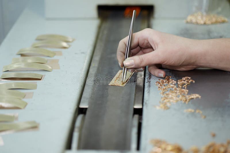 Mano femenina con las pinzas, items del oro fotografía de archivo libre de regalías Mano femenina con las pinzas, items del oro fotografía de archivo libre de regalías