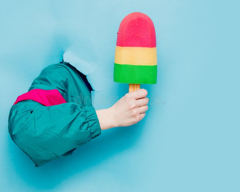 Mano femenina en la chaqueta del estilo 90s que sostiene el helado fotos de archivo libres de regalías Mano femenina en la chaqueta del estilo 90s que sostiene el helado fotos de archivo libres de regalías