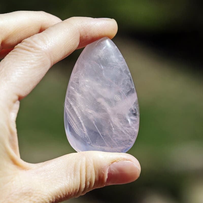 Mano femenina que sostiene la piedra preciosa procesada foto de archivo libre de regalías Mano femenina que sostiene la piedra preciosa procesada foto de archivo libre de regalías