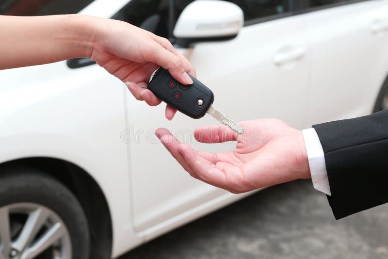 Mano femminile che fornisce una chiave per il compratore o l'automobile locativa fotografie stock libere da diritti Mano femminile che fornisce una chiave per il compratore o l'automobile locativa fotografie stock libere da diritti