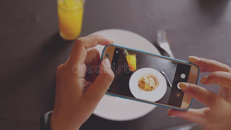 Mano femminile che prende alcune foto dal suo cellulare di un piatto italiano delizioso dell'alimento Fine in su immagine stock Mano femminile che prende alcune foto dal suo cellulare di un piatto italiano delizioso dell'alimento Fine in su immagine stock