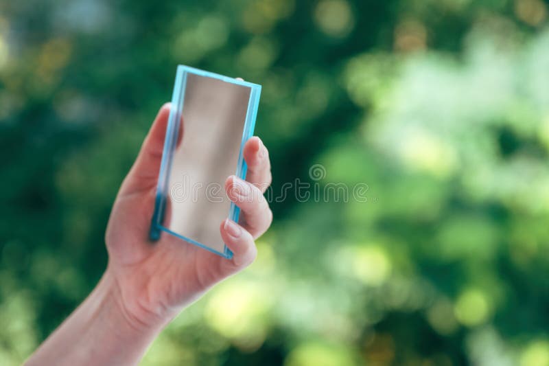 Mano femminile con piccolo specchio di bellezza fotografia stock libera da diritti