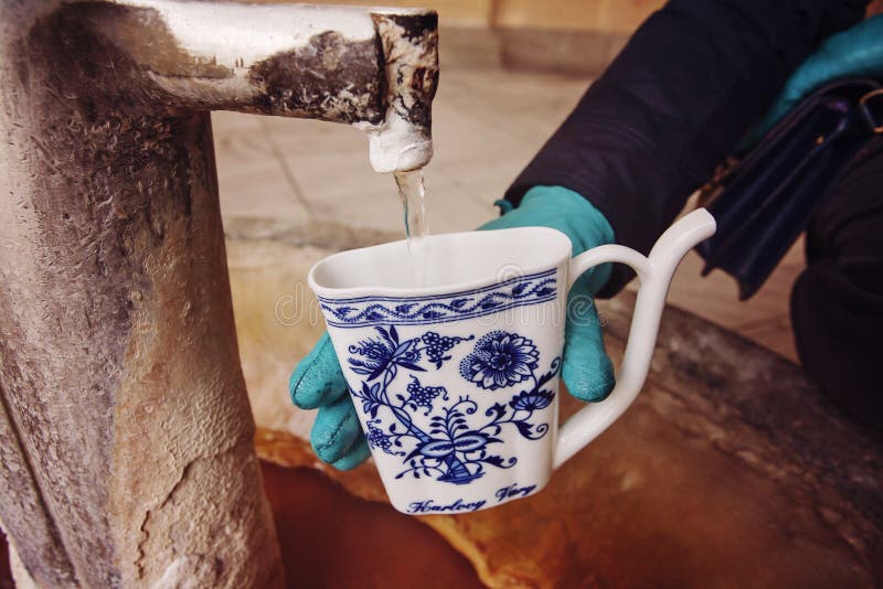 Si Riempie D Acqua Calda Mano In Guanto Che Riempie Una Tazza Di Acqua Minerale Terapeutica Ad