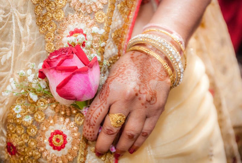 Indian bride hand painted with henna tattoo, holding a red rose. Indian bride hand painted with henna tattoo, holding a red rose