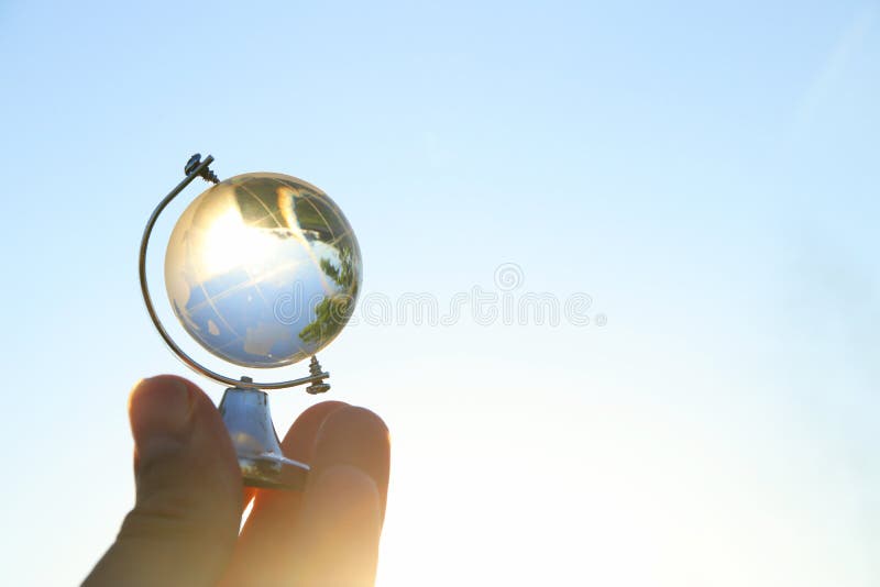 mano maschio che tiene piccolo globo di cristallo davanti a cielo blu fotografia stock libera da diritti mano maschio che tiene piccolo globo di cristallo davanti a cielo blu fotografia stock libera da diritti