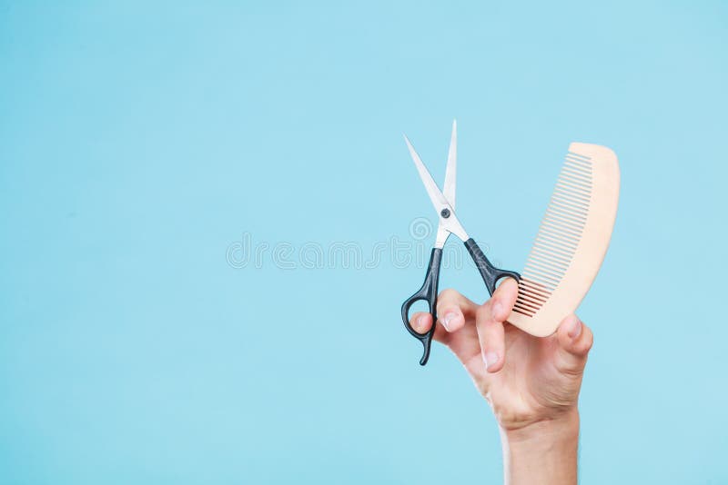 Mano maschio con le forbici ed il pettine fotografia stock libera da diritti Mano maschio con le forbici ed il pettine fotografia stock libera da diritti
