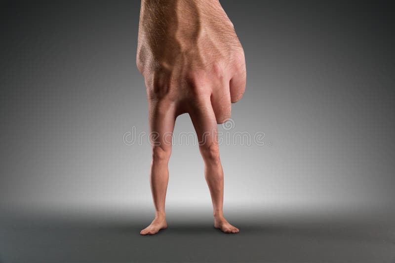 Mano masculina con las piernas imagen de archivo Mano masculina con las piernas imagen de archivo