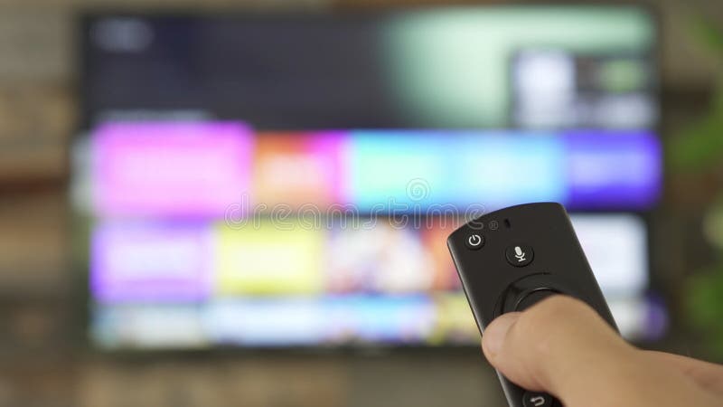 Mano masculina sujeta el mando a distancia de la tv y cambia los canales de tv